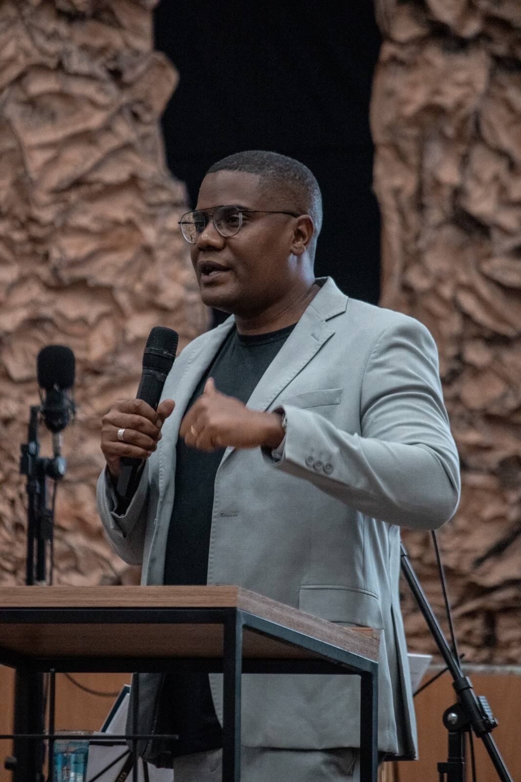Douglas Dias falando ao microfone durante palestra
